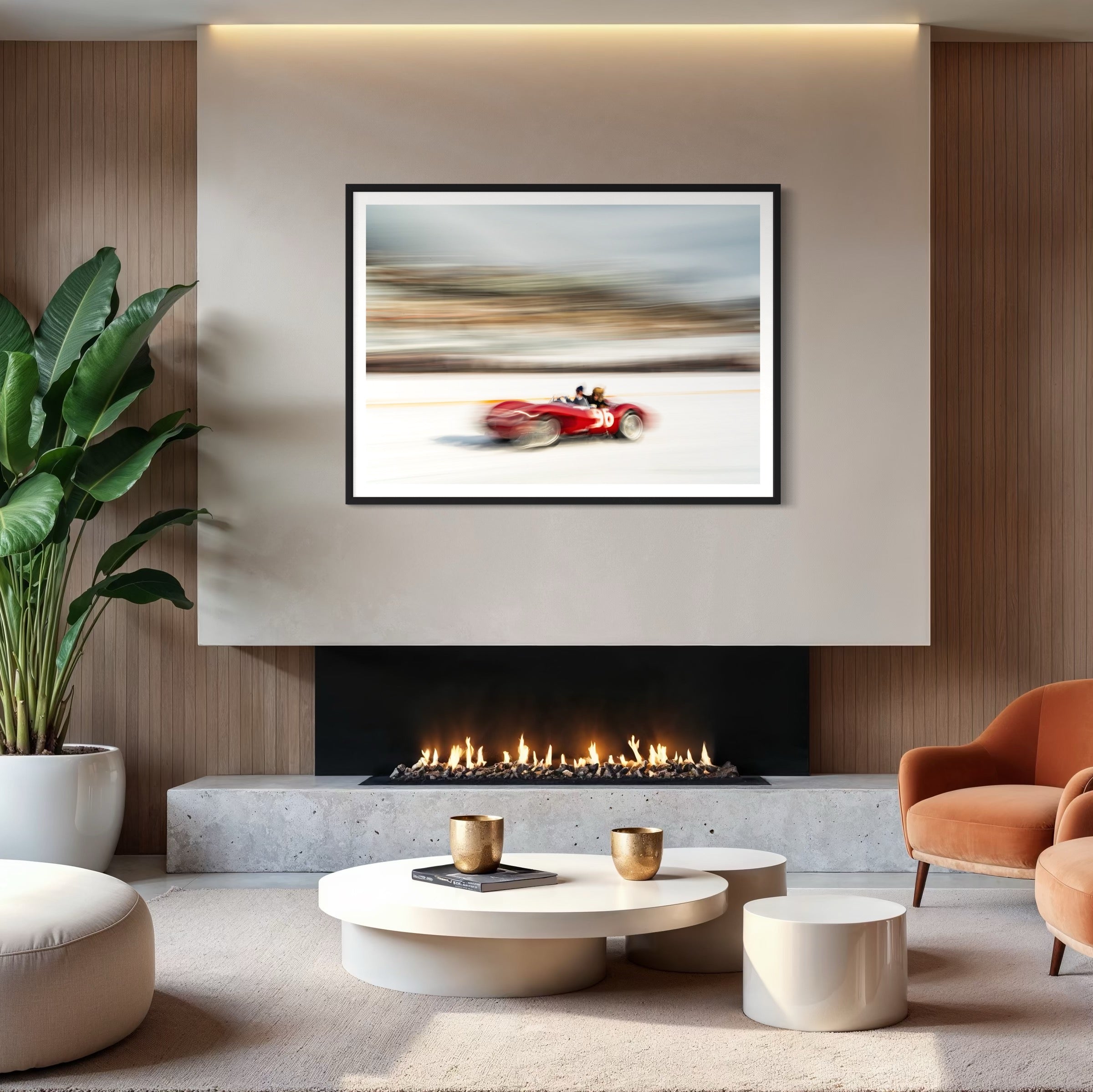 Modern living room with a fireplace, artwork of a red car, and decorative items.